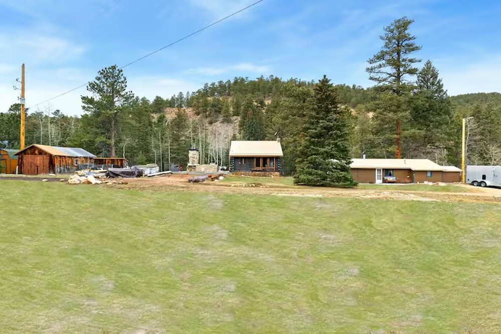 The wide flat green lawn among the cabins and pines