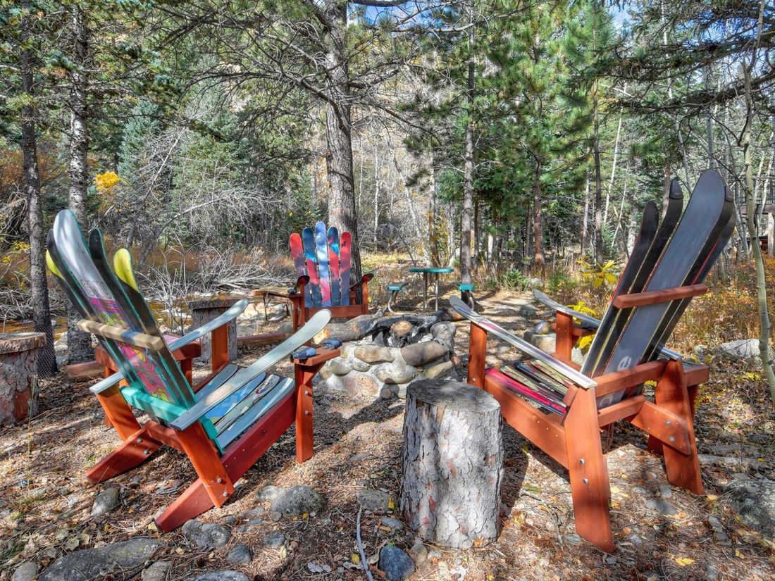 Adirondack chairs built from repurposed skis around a fire pit